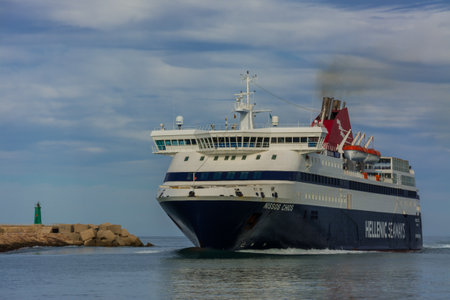 Denia, Alicante, Spain, november 21, 2018: A Greek ferry entering the harbor next to the green beacon lighthouse at the entranceのeditorial素材