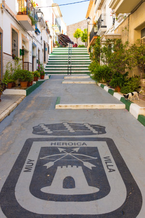 Calpe, Alicante, Spain. May 10, 2019: Street of the old town with the coat of arms of the city painted on the ground. Translation: 'Very heroic villa'のeditorial素材