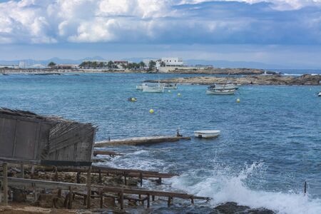 Fishing boats near a jetty in Es Pujols coast. Northeast of the islandの写真素材