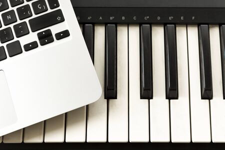 Keyboard and computer. Concepts of learning to play music online at home, working from home, self-taught or autodidactの写真素材
