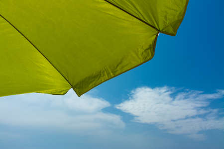 Bottom of a beach umbrella with the blue sky and some clouds in the background. Summer, vacation or safety conceptsの写真素材