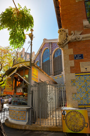 Valencia, Spain. October 11, 2020: Building of the central market of the city, with typical street stalls outside. On the sign on the corner: market square, in Valencian languageのeditorial素材