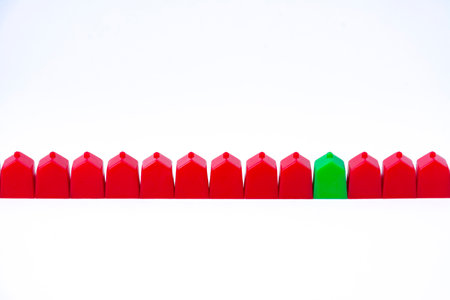 Groups of toy houses of two different colors on table and white background. Concepts such as choice, different neighborhoods or social classesの写真素材