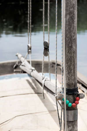 Mast and boom of a small old sailing boat, with ropes and pulleysの写真素材