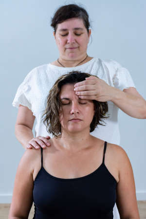 Woman receiving alternative therapeutic massage with fingers pressure on foreheadの写真素材