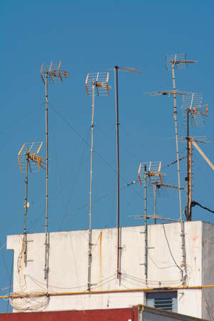 Some masts with television antennas, on the roof of a residential buildingの写真素材
