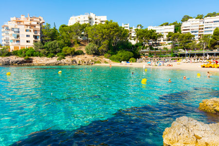 Ses Illetes, Majorca, Balearic islands, Spain. July 20th, 2022 - Terrace of the restaurant of the Balneario Illetas spa next to the beach, with umbrellas and loungers and pedal boatsのeditorial素材
