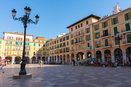 Palma, Mallorca, Balearic Islands, Spain. July 21, 2022 - The buildings of the Plaza Mayor in Palma, the main square surrounded by arcades, with terraces of bars, restaurants and shopsのeditorial素材