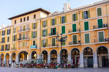 Palma, Mallorca, Balearic Islands, Spain. July 21, 2022 - The buildings of the Plaza Mayor in Palma, the main square surrounded by arcades, with terraces of bars, restaurants and shopsのeditorial素材