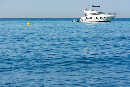 Yacht moored near the coast, with buoys in the waterの写真素材