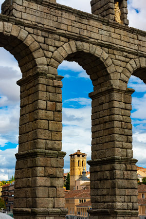 Segovia, Spain. September 14, 2022 - Bell tower of the church of the Savior (Salvador) between the arches of the romanesque aqueduct of Segoviaのeditorial素材