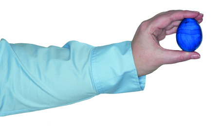 Female arm holding a blue egg in the handの写真素材