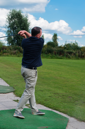 Golf player at tee off on a golf courseの写真素材