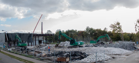Demolition excavator rips off a building