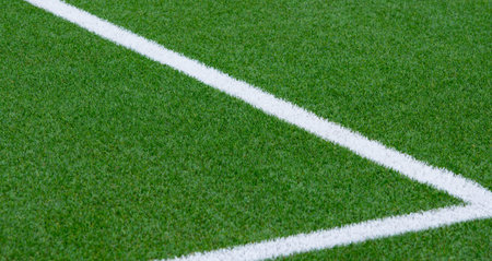 Close up on soccer field with artificial grass and white stripes