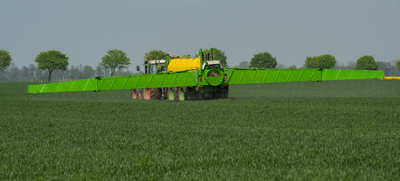 Tractor with field sprayer when applying pesticide against pesticide