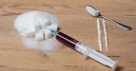 Sugar, cake and cocaine on a wooden plate, what makes sugar or cocaine addictingの写真素材