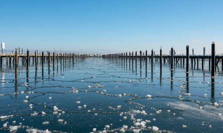 The marina at the Ostseebad GrÃ¶mitz on the Baltic Sea frozen over in winterの写真素材