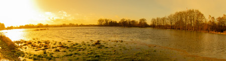 Sunset, fields and meadows flooded after a stormの写真素材