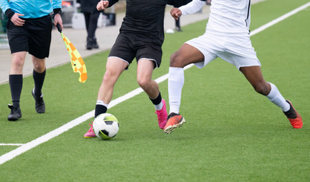 Football player on an artificial turf in a duel while playing footballの写真素材
