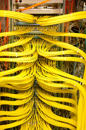 Yellow RJ45 copper cable - Network Cable in a network distribution rack in the data centerの写真素材