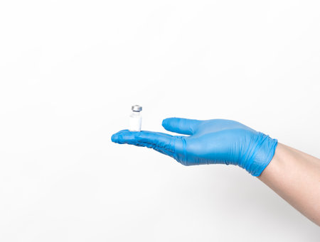 Doctor holding a small vial of vaccine in her handの写真素材