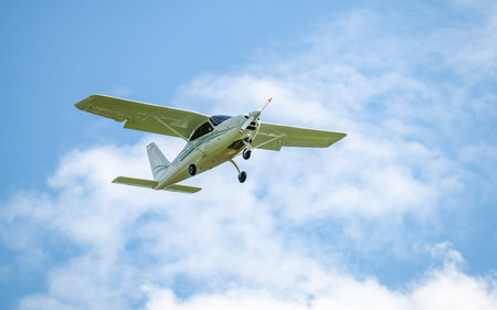 single-engine aircraft - light aircraft in the air against a blue sky and white clouds