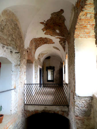 Old stone masonry under white plaster walls in the arched corridor of an old medieval castle. Chinadiyevo Castle of St. Miklosの写真素材