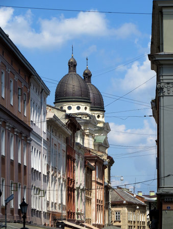 Old buildings of the street of a European city and the dome of the church on the background of the...