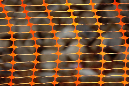 abstract background of orange metal mesh with holes in the form of a gridの写真素材