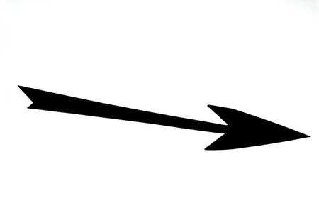 Black-and-white photo of a single arrow on a dark background, a sign for presentationsの素材