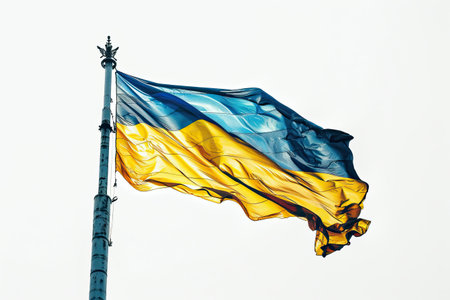 The Ukraine flag waves majestically in the air, showing its vibrant blue and yellow colors. Against a pure white background, this display symbolizes national pride, unity, and resilience. The flag's movement reflects the spirit of the nation and its people's unwavering hope for peace and progress.の素材