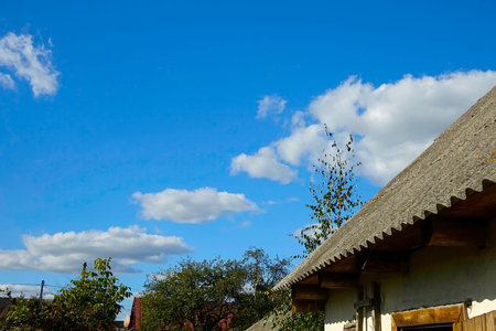 The photo captures an old slate roof atop a quaint building in a picturesque village, set against a...