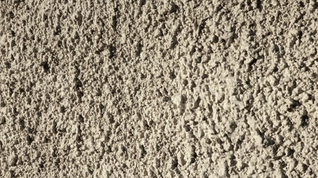 Close-up view of a textured plaster wall showing its unique patterns and shades.の写真素材