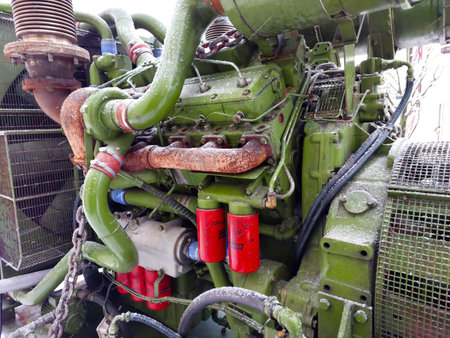 A close-up of a diesel generator engine showing fuel and oil filters, highlighting its intricate...