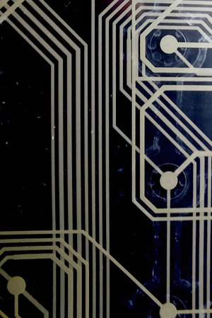 Detailed printed circuit board showcases complex wiring designs set against a deep black backdrop.