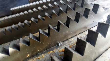 Heavy-duty steel knives are intricately arranged within a fruit crusher, ready to process fresh produce into juice. The metallic gleam reflects culinary potential.の写真素材