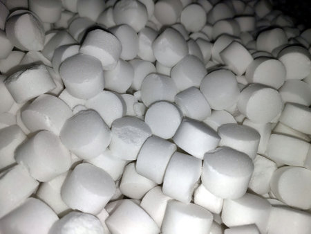 White tablet salt pieces are piled high, showcasing a captivating arrangement. The uniform shapes reflect light, emphasizing their crystalline texture and simplicity.の写真素材