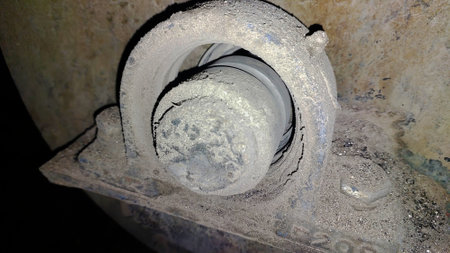Close-up view of a damaged bearing support in a machinery environment, showing significant wear and dust accumulation likely due to prolonged use and neglect.の写真素材