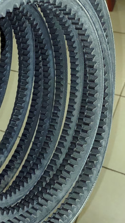 Several toothed V belts are neatly arranged, showing their ribbed structure designed to enhance grip in drive applications. These belts ensure effective power transmission.の写真素材