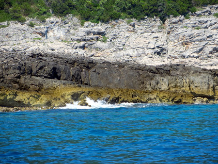 Visit the stunning, rocky shoreline of Montenegro. Waves gently crash against the cliffs, showing the natural beauty of the Adriatic. A perfect spot for nature lovers.の写真素材