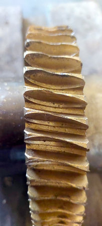 Close-up of a bronze worm gear wheel, highlighting its unique ridged structure and metallic texture. This piece is crucial for mechanical functions in various machines.の写真素材