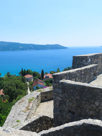 Visitors trek through the historic Kanli Kula Fortress in Herceg Novi, enjoying panoramic vistas of the azure Bay of Kotor and picturesque coastal homes.の写真素材
