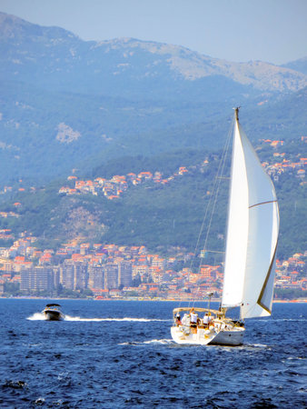 Herceg Novi, Montenegro A sailing yacht glides across the tranquil waters of Boka Kotorska, with...