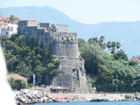 Herceg Novi Citadel stands proudly on a hillside, offering stunning views of the serene Bay of Kotor. Lush greenery surrounds the historic structure under a bright blue sky.の写真素材