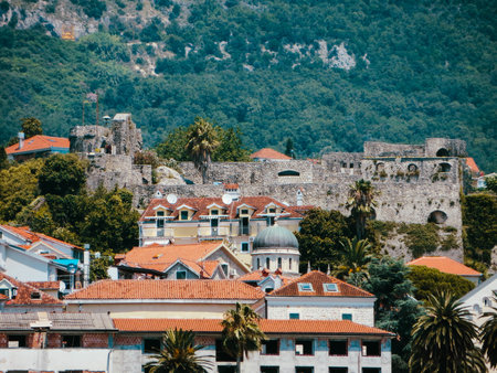 Historic fortresses rise above the colorful rooftops of Herceg Novi, framed by vibrant greenery and the breathtaking Bay of Kotor, showing the city's rich heritage.の写真素材