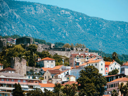 Herceg Novi features stunning coastal views, historic fortresses, and vibrant buildings nestled against the backdrop of the Boka Kotorska mountains, showing its rich history.の写真素材