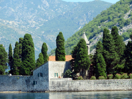 Explore the beauty of Saint George island in Kotor Bay, Montenegro, featuring its peaceful church and lush greenery against the majestic mountains.の写真素材