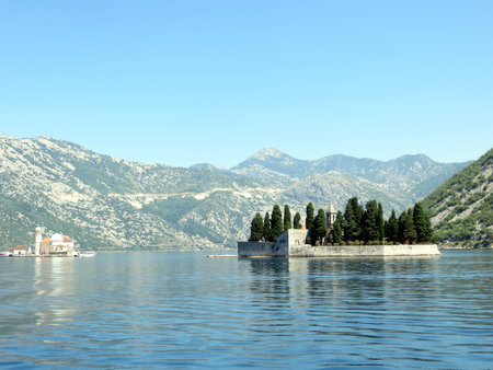 Kotor Bay showcases its stunning beauty with the islands of Saint George and Our Lady of the Rocks, surrounded by serene waters and majestic mountains in the background.の写真素材