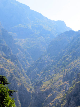 The breathtaking mountains of Kotor rise dramatically, showcasing rugged terrain and vibrant greenery under a clear sky. This stunning landscape invites adventure.の写真素材